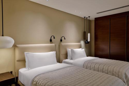 two beds sitting next to each other in a room at Le Méridien Dubai Hotel & Conference Centre in Dubai