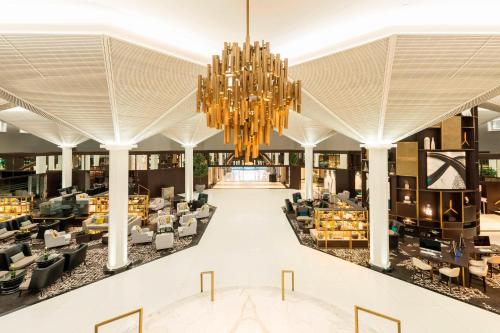 a rendering of the lobby of a hotel with a chandelier at Le Méridien Dubai Hotel & Conference Centre in Dubai