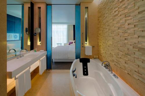 a bathroom with a tub and two sinks and a bedroom at Le Meridien Dubai Hotel, Royal Club & Conference Centre in Dubai