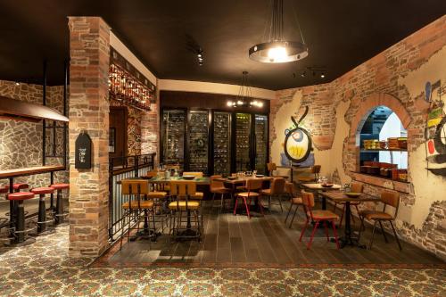a restaurant with tables and chairs and a brick wall at Le Méridien Dubai Hotel & Conference Centre in Dubai