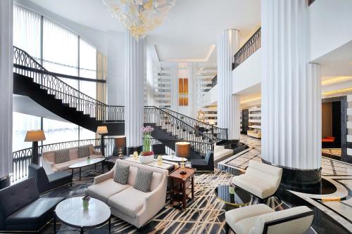 a lobby with couches and tables and a staircase at The St. Regis Amman in Amman