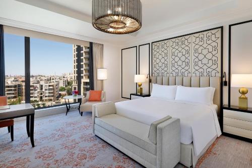 a bedroom with a bed and a couch and a desk at The St. Regis Amman in Amman