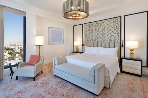a bedroom with a large white bed and a chair at The St. Regis Amman in Amman
