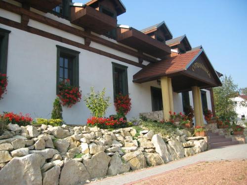 a house with a stone wall and a stone building at Cyprianówka in Warszowice