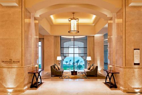 a lobby of a hotel with chairs and a chandelier at The St. Regis Saadiyat Island Resort, Abu Dhabi in Abu Dhabi