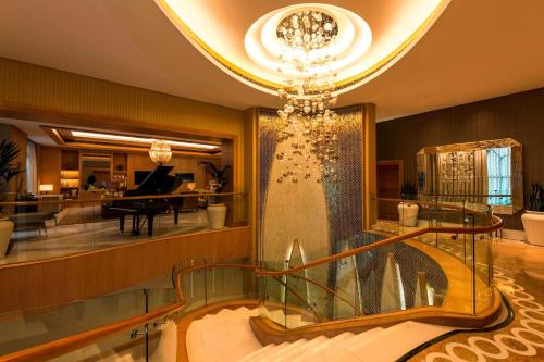 a hotel lobby with a chandelier and a staircase at The St. Regis Saadiyat Island Resort, Abu Dhabi in Abu Dhabi