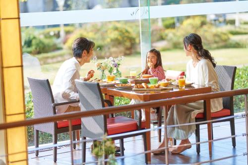 a family sitting at a table eating food at Sheraton Grande Tokyo Bay Hotel in Urayasu