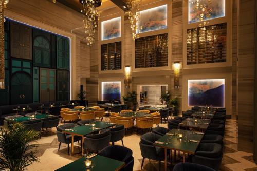a dining room with green tables and chairs at The St. Regis Saadiyat Island Resort, Abu Dhabi in Abu Dhabi