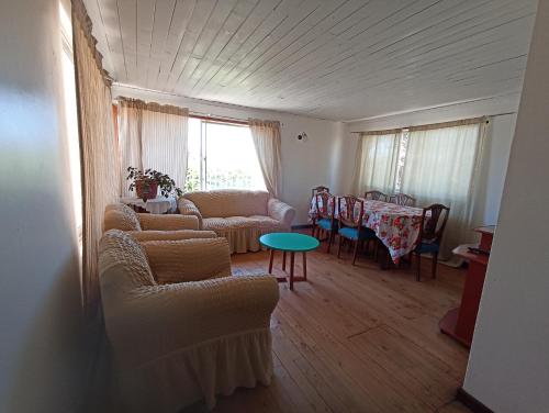 a living room with two couches and a table at Cabaña Anita in El Quisco