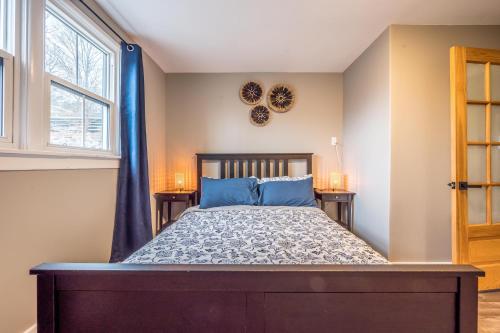 a bedroom with a bed with blue pillows and a window at Cozy Chic Oasis 3 Bedroom in Halifax