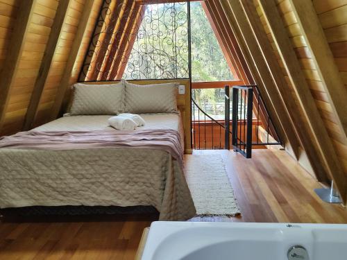 Katil atau katil-katil dalam bilik di Chalé Magia das Hortênsias, relaxe na hidromassagem!