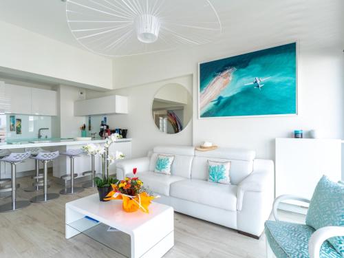 un salon avec un canapé blanc et une cuisine dans l'établissement Appartement climatisé avec parking et balcon à Arcachon - FR-1-319-459, à Arcachon