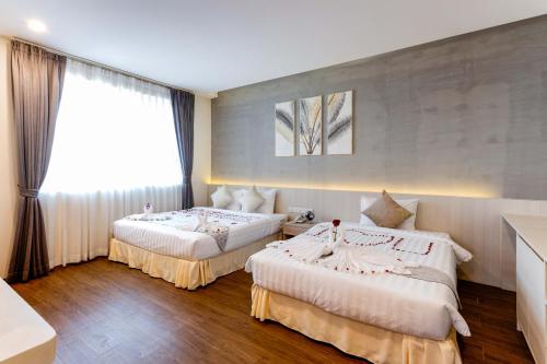 Un pat sau paturi într-o cameră la Joli Hotel