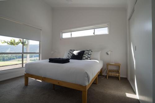 a white bedroom with a bed and a window at Stay in Mudgee in Mudgee