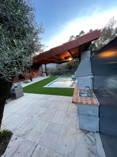 a outdoor grill with a roof on a patio at Perfect Mountain Lodge with Pool in Fafião