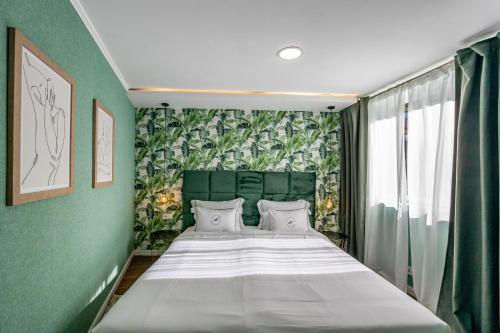 Un dormitorio con una cama grande con una pared verde. en Bossa & Bed Hostel, en Lisboa