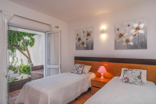 1 Schlafzimmer mit 2 Betten und einem Fenster in der Unterkunft Casa Caravela, Praia da Luz in Luz