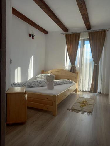 a bedroom with a bed in a room with windows at Conacul Elenei in Poiana Mărului