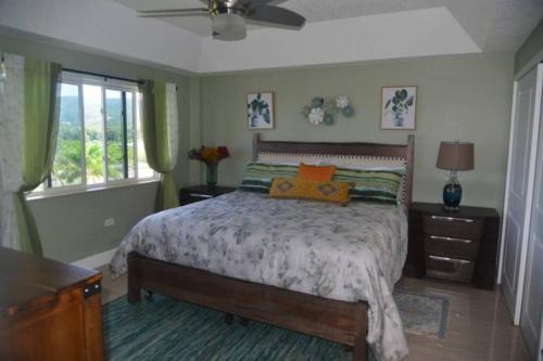 Schlafzimmer mit einem Bett und einem Deckenventilator in der Unterkunft 3Bedroom Vacation Condo Resort 3 in Ocho Rios