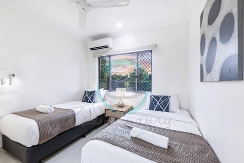 zwei Betten in einem Zimmer mit Fenster in der Unterkunft Zenhouse: Stylish Muirhead Home Near Park/Hospital in Leanyer