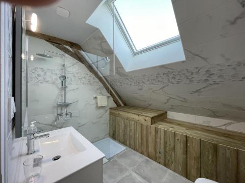 a bathroom with a sink and a shower and a window at Maison de ferme rénovée 18ème avec jardin, cheminée, Wi-Fi et parking - FR-1-489-433 in Ygrande