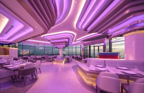 a restaurant with purple lighting and tables and chairs at Grande Centre Point Space Pattaya in Pattaya North