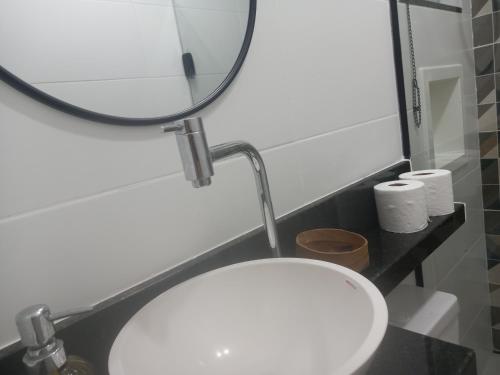 baño con espejo y lavabo blanco en Suhcasa Bairro de Fátima 02, en Río de Janeiro