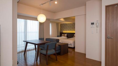 a room with a table and a bed and a bedroom at Hotel Global View Hakodate in Hakodate