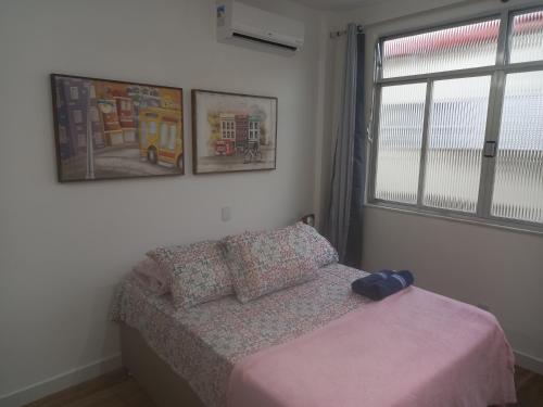 Habitación pequeña con cama y ventana en Suhcasa Bairro de Fátima 02, en Río de Janeiro