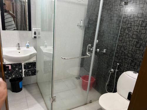 a bathroom with a shower and a toilet and a sink at Sunshine Beach Villa - Kuzhuppilly in Cherai Beach
