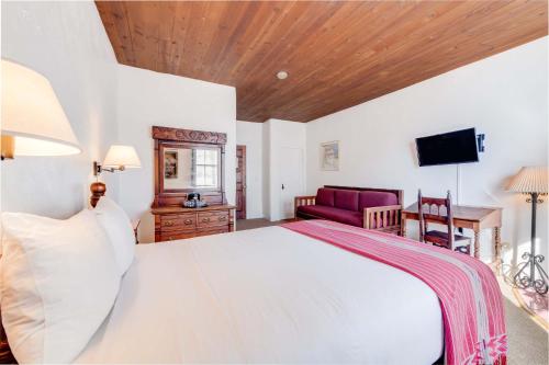 a bedroom with a large white bed with a wooden ceiling at The Historic Taos Inn in Taos