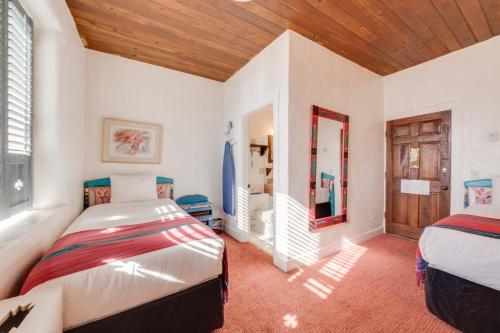 a bedroom with two beds and a wooden ceiling at The Historic Taos Inn in Taos