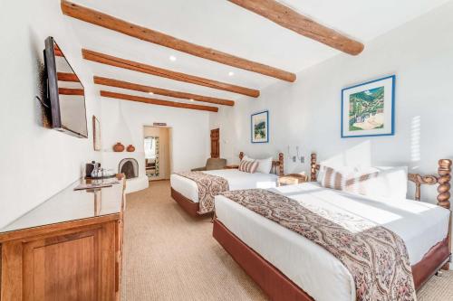 a hotel room with two beds and a tv at The Historic Taos Inn in Taos