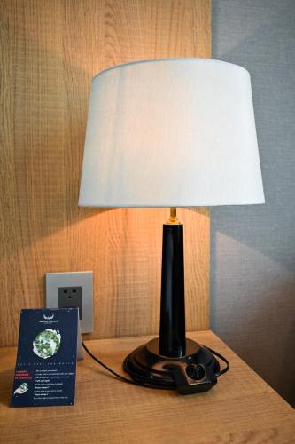 a lamp sitting on a table next to a book at Muong Thanh Grand Saigon Centre Hotel in Ho Chi Minh City