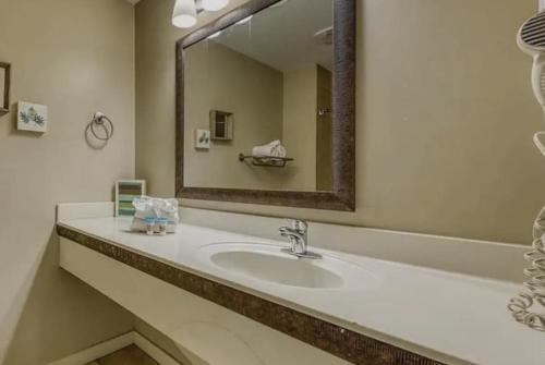 a bathroom with a sink and a large mirror at Origin at Seahaven in Panama City Beach