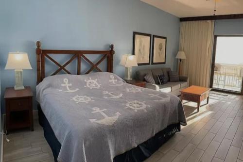 a bedroom with a bed and a living room at Origin at Seahaven in Panama City Beach