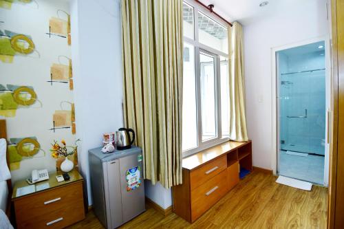 een slaapkamer met een koelkast en een raam bij Hotel Thu Ha - Sân bay Tân Sơn Nhất in Ho Chi Minh-stad