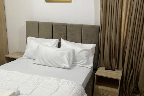 ラゴスにあるBeautiful 2Br Apt in Ogba, Ikeja, Lagosのベッドルーム1室(白いシーツと枕のベッド1台付)