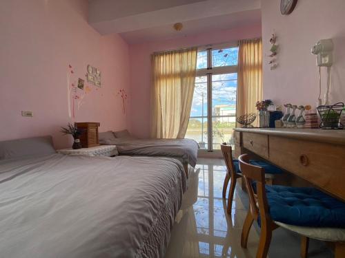 員山鄉的住宿－豐綠民宿 Yilan Fenglu Homestay，一间卧室设有两张床、一张桌子和一个窗口。