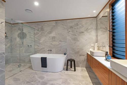 La salle de bains est pourvue d'une baignoire et d'un lavabo. dans l'établissement Indigo at Funnel Bay, à Airlie Beach