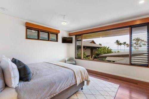 a bedroom with a bed and a large window at Indigo at Funnel Bay in Airlie Beach