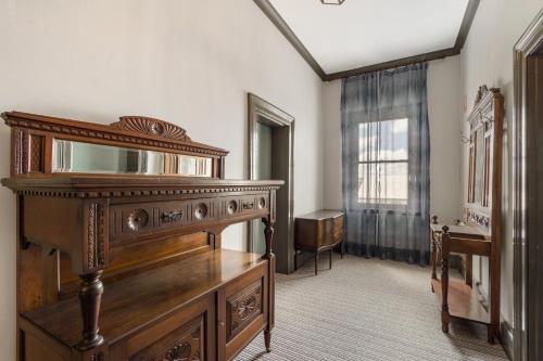 a room with a wooden dresser and a mirror at The Great Western Hotel in Orange