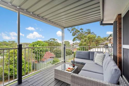 a living room with a couch on a balcony at The Wreck Room Holiday House close to the Beach with Ample Boat Parking in Shoal Bay