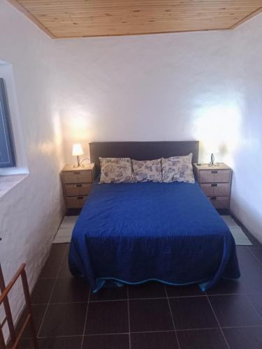 a bedroom with a blue bed with two night stands at Casa Do Forno - Quinta Amoreira in Faro