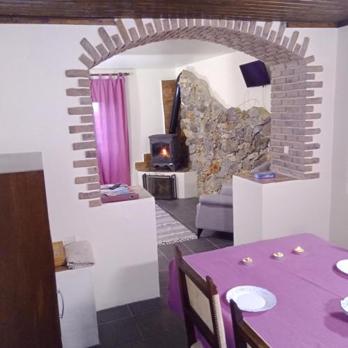 a living room with a table and a stone fireplace at Casa Amoreira - Quinta Amoreira in Faro