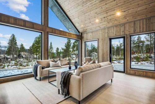 sala de estar con 2 sofás y ventanas grandes en Brand new cabin at Hovden cross-country skiing, en Hovden
