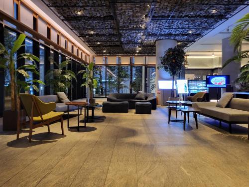 a lobby with couches and tables in a building at Sotetsu Hotels The Splaisir Seoul Myeongdong in Seoul
