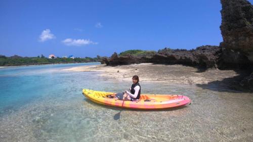 a person sitting on a kayak in the water at Hotel Miyuki Beach in Onna