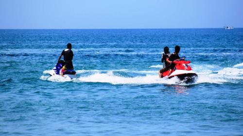 a group of people riding on a jet ski in the water at Hotel Miyuki Beach in Onna