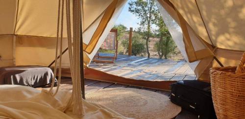 a room with a tent with a wooden deck at Sublim' Ecolodge in Abela